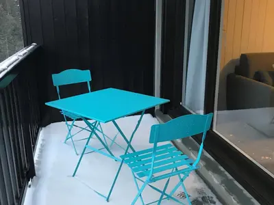 two blue chairs and a table on a balcony at Appartement rénové, Balcon sud, Animaux admis, Parking en option - FR-1-425-155 in Flaine