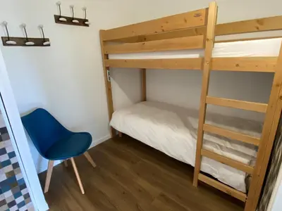 a bedroom with a bunk bed and a blue chair at Appartement rénové, Balcon sud, Animaux admis, Parking en option - FR-1-425-155 in Flaine