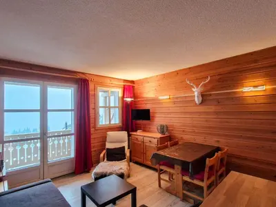 a living room with a wooden wall with a table and a window at Studio lumineux avec balcon - Flaine - FR-1-425-160 in Flaine