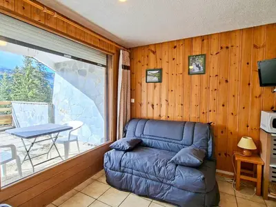 a living room with a couch in front of a window at Studio confortable au centre station avec terrasse, animaux admis - FR-1-425-181 in Flaine
