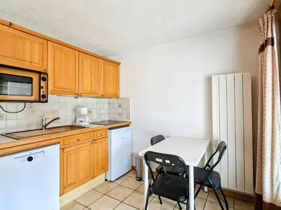 a small kitchen with a small table and chairs at Studio confortable au centre station avec terrasse, animaux admis - FR-1-425-181 in Flaine