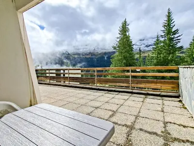 a balcony with a bench and a view of a mountain at Studio confortable au centre station avec terrasse, animaux admis - FR-1-425-181 in Flaine