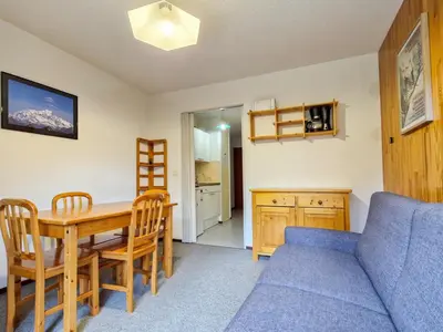a living room with a table and a blue couch at Studio cabine confortable à Flaine, balcon sud, proche pistes - FR-1-425-171 in Flaine