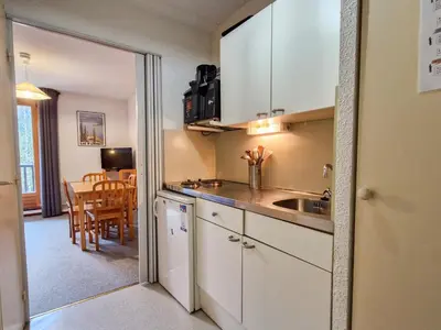 a kitchen with white cabinets and a dining room at Studio cabine confortable à Flaine, balcon sud, proche pistes - FR-1-425-171 in Flaine