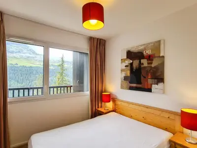 a bedroom with a bed and a window at Appartement confortable avec balcon et parking couvert - FR-1-425-143 in Flaine
