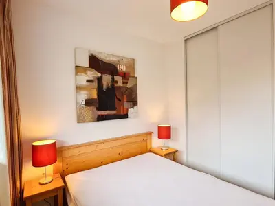 a bedroom with a white bed and two lamps at Appartement confortable avec balcon et parking couvert - FR-1-425-143 in Flaine