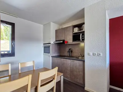 a kitchen with a wooden table and a dining room at Appartement au pied des pistes avec piscine et parking - FR-1-425-189 in Flaine