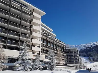 a building with snow covered trees in front of it at Appartement au pied des pistes avec piscine et parking - FR-1-425-189 in Flaine