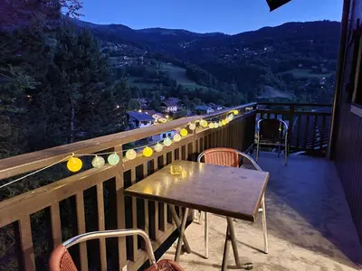 a table and chairs on a balcony with a view at Appartement dans châlet avec piscine couverte in Saint-Gervais-les-Bains