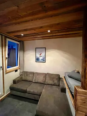 a living room with a couch and a bed at Le Nid de l'Aiguille - Au pied de l'Aiguille du midi in Chamonix-Mont-Blanc