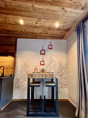 a table in a room with a wall with snow covered trees at Le Nid de l'Aiguille - Au pied de l'Aiguille du midi in Chamonix-Mont-Blanc