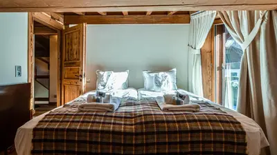 two beds in a room with a large window at Chalet Entre Nous in Chamonix-Mont-Blanc