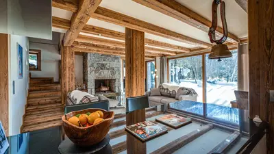 a living room with a stone fireplace and a couch at Chalet Entre Nous in Chamonix-Mont-Blanc