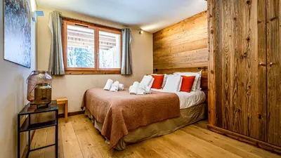 a bedroom with a bed and a wooden wall at Chalet du Bois in Chamonix-Mont-Blanc