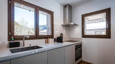 a white kitchen with a sink and a window at Chalet Etoile in Chamonix-Mont-Blanc