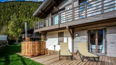 a living room with a couch and a big screen tv at Chalet Etoile in Chamonix-Mont-Blanc