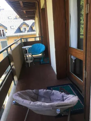 a balcony with a bed and a table and a chair at LE PARADISO centre SAINT-GERVAIS in Saint-Gervais-les-Bains