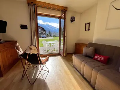 a living room with a couch and a large window at Studio avec vue montagnes et piscines, animaux acceptés - FR-1-624-108 in Samoëns
