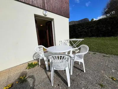 a white table and four chairs sitting outside a building at Studio avec vue montagnes et piscines, animaux acceptés - FR-1-624-108 in Samoëns