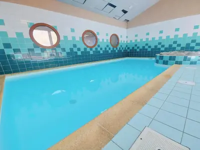 a large swimming pool with two mirrors on the wall at Studio avec vue montagnes et piscines, animaux acceptés - FR-1-624-108 in Samoëns