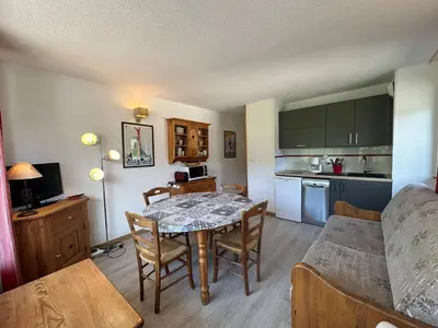 a living room with a dining room table and a kitchen at Bel appartement 36m² rénové, sans internet, 2 ch, 6 couchages à Morillon - FR-1-642-67 in Morillon
