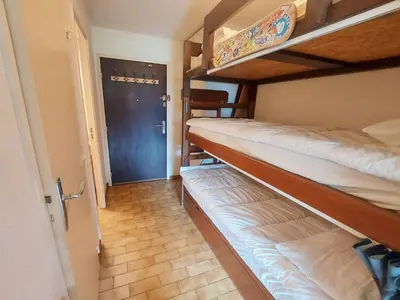 a room with two bunk beds and a door at Studio cosy au centre de Samoëns, animaux acceptés - FR-1-624-110 in Samoëns