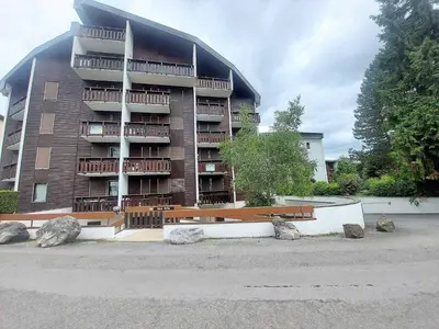 a large apartment building with rocks in front of it at Studio cosy au centre de Samoëns, animaux acceptés - FR-1-624-110 in Samoëns
