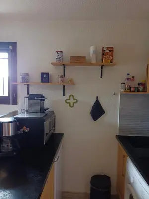 a kitchen with a counter with a microwave on the wall at Appartement - Combloux in Combloux