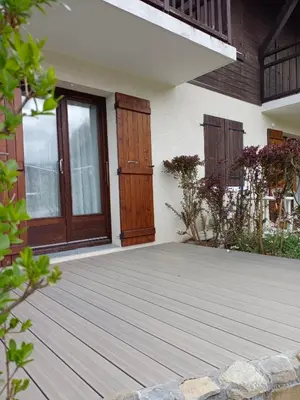 a house with wooden doors and a deck at Appartement - Combloux in Combloux