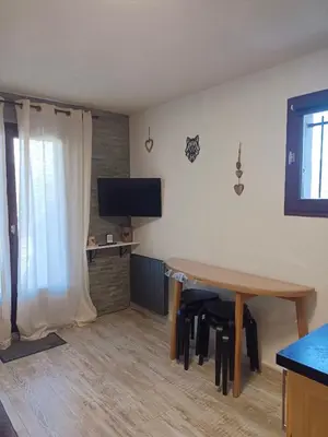 a living room with a table and chairs and a television at Appartement - Combloux in Combloux