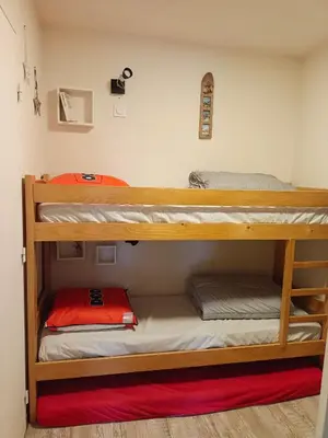 two bunk beds in a dorm room with a red rug at Appartement - Combloux in Combloux