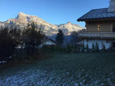 a house with a mountain in the background at Chalet Le Paddock in Saint-Gervais-les-Bains
