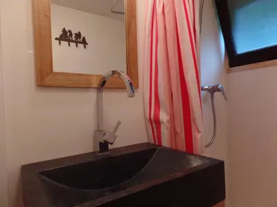 a bathroom with a black sink and a red shower curtain at Chalet Le Paddock in Saint-Gervais-les-Bains