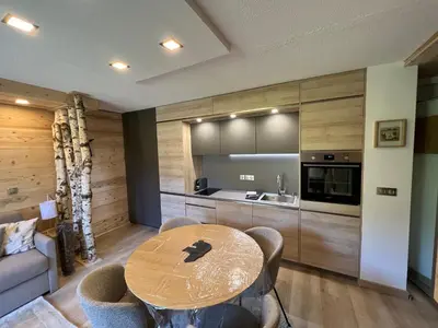 a dining room with a table and a kitchen at Le Sapin B19 Megeve - Demi Quartier in Megève