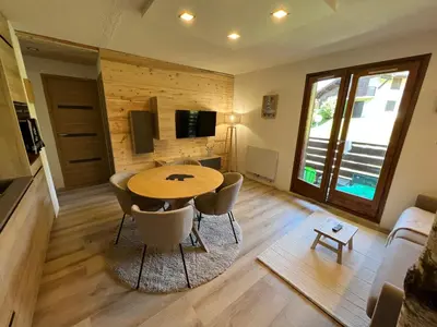 a living room with a table and chairs and a television at Le Sapin B19 Megeve - Demi Quartier in Megève