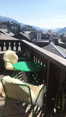 a green table and chairs on a balcony at Tatiana 2 in Megève