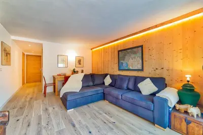 a living room with a blue couch and a table at California in Chamonix-Mont-Blanc