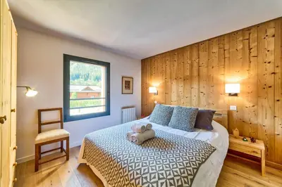 a bedroom with a bed with a teddy bear on it at California in Chamonix-Mont-Blanc
