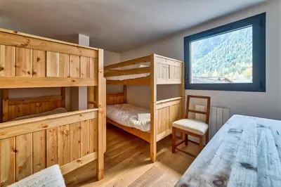a bedroom with two bunk beds and a window at California in Chamonix-Mont-Blanc