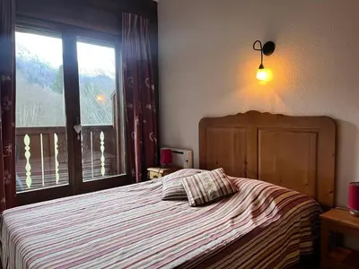 a bedroom with a bed with a large window at Chalet 3 chambres avec piscine et parking à Samoëns - FR-1-624-111 in Samoëns