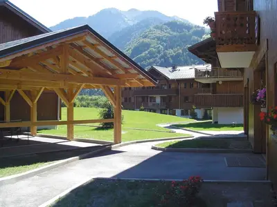 a group of buildings with a large wooden pavilion at Chalet 3 chambres avec piscine et parking à Samoëns - FR-1-624-111 in Samoëns