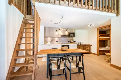 a kitchen with a wooden table and some stools at Apartment Celosia Chamonix - by EMERALD STAY in Chamonix-Mont-Blanc