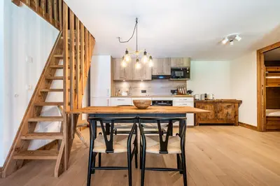 a kitchen with a wooden table and some chairs at Apartment Celosia Chamonix - by EMERALD STAY in Chamonix-Mont-Blanc