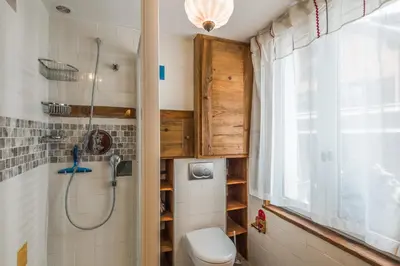 a bathroom with a shower and a toilet and a window at Appartement de l'Alpage - Welkeys in Megève