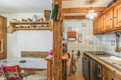 a kitchen with wooden cabinets and a table in it at Appartement de l'Alpage - Welkeys in Megève