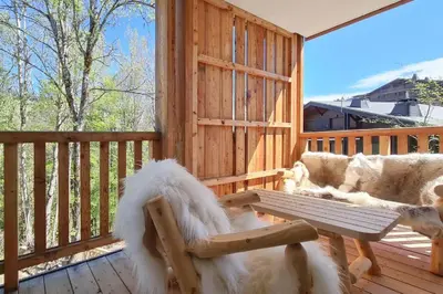 a dog sitting on a wooden deck with a bench at Apache_Coudriers in Megève