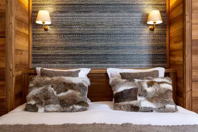 a bedroom with a bed with faux fur pillows at Apache_Coudriers in Megève