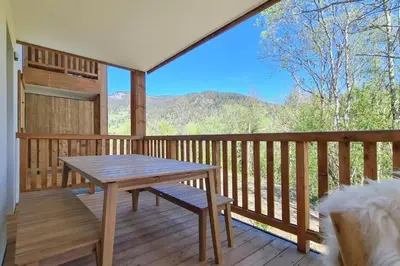a wooden deck with a wooden table and bench on it at Apache_Coudriers in Megève