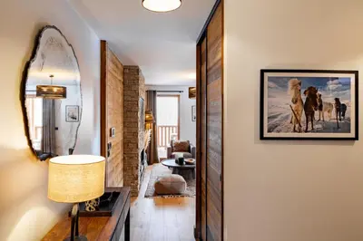 a living room with a painting of horses on the wall at Apache_Coudriers in Megève