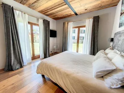 a bedroom with a large bed with wooden ceilings and windows at LES ALPES III in Chamonix-Mont-Blanc